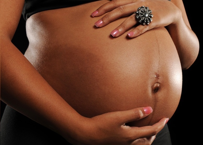 African American Woman pregnant against a black background; Shutterstock ID 60729988; PO: KTRK